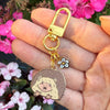 Keychain with hedgehog charm held in front of flowers