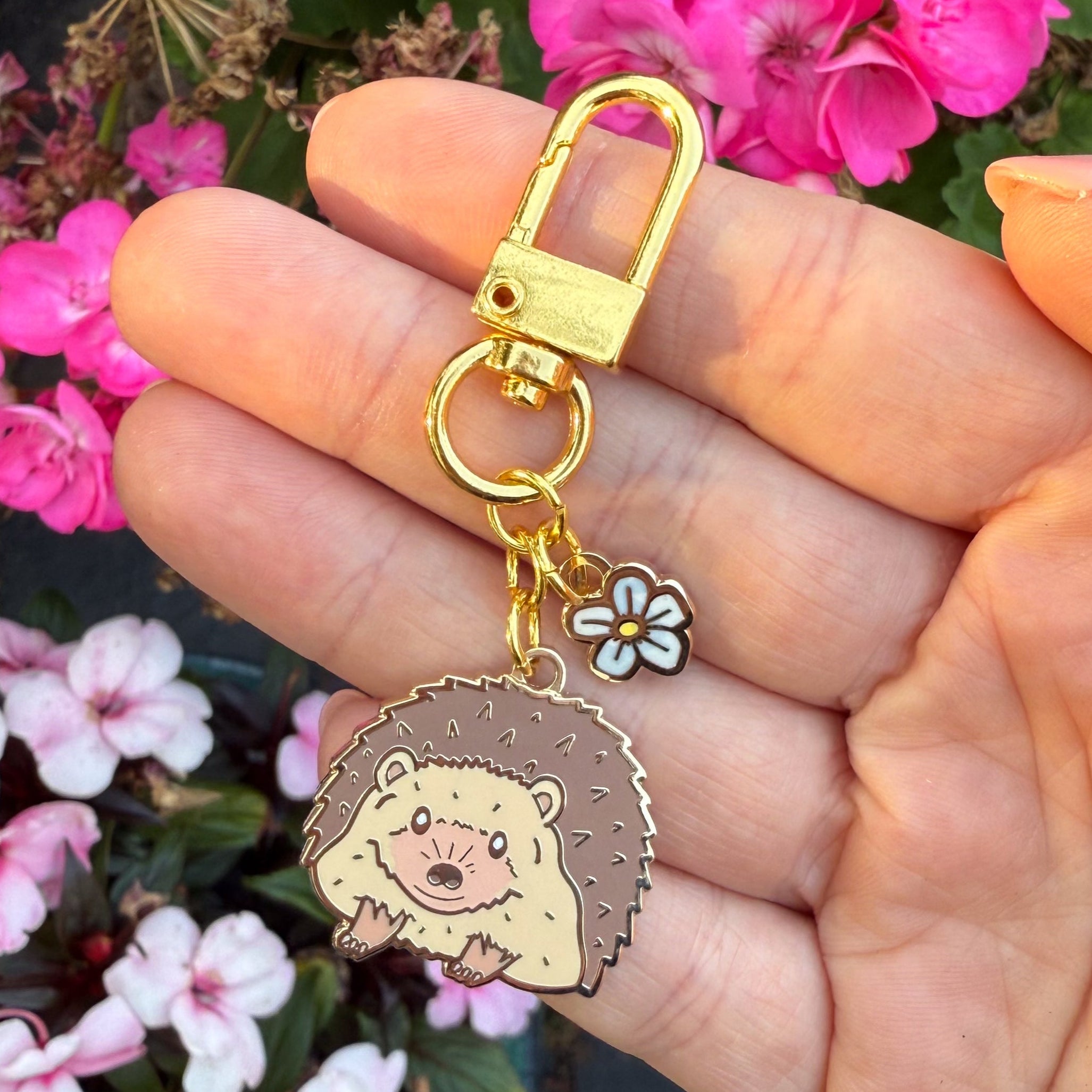 Keychain with hedgehog charm held in front of flowers